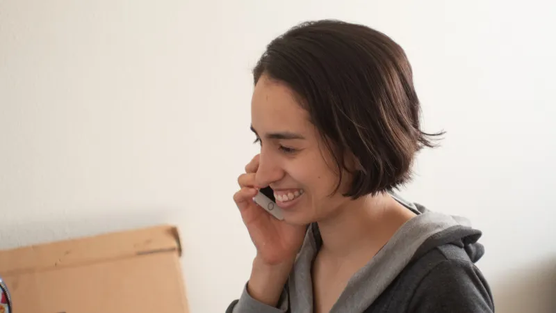 a woman talking on a cell phone and smiling