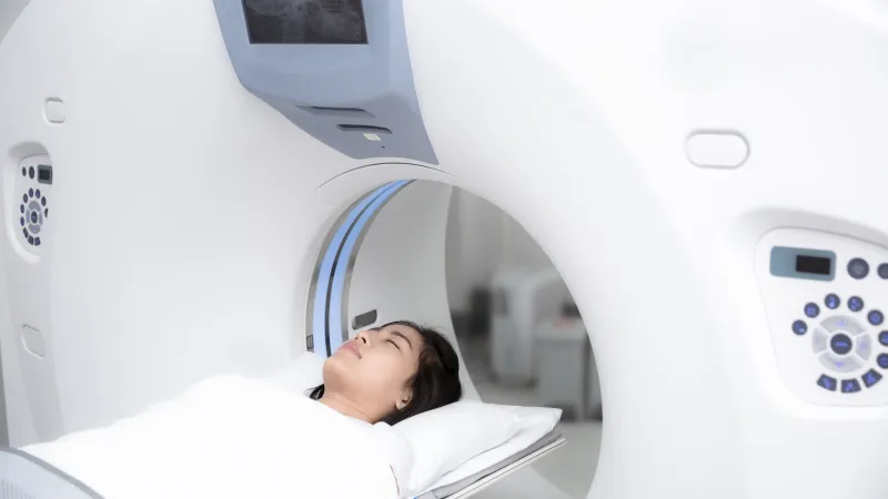 A woman undergoing a CT scan in a modern medical imaging room.