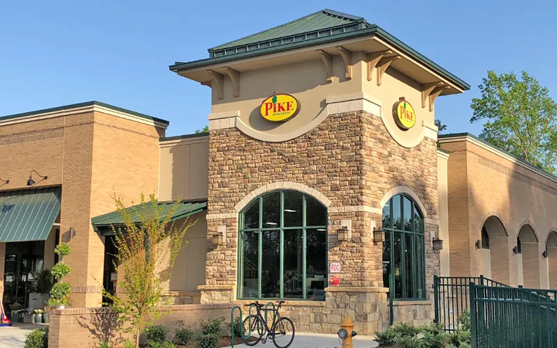 a small clock tower in front of a brick building