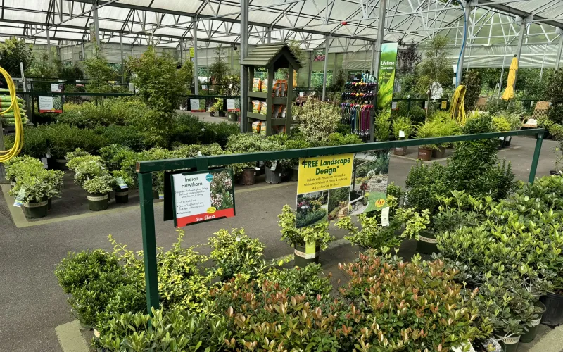 a greenhouse with plants and signs with Gaylord Opryland Resort & Convention Center in the background