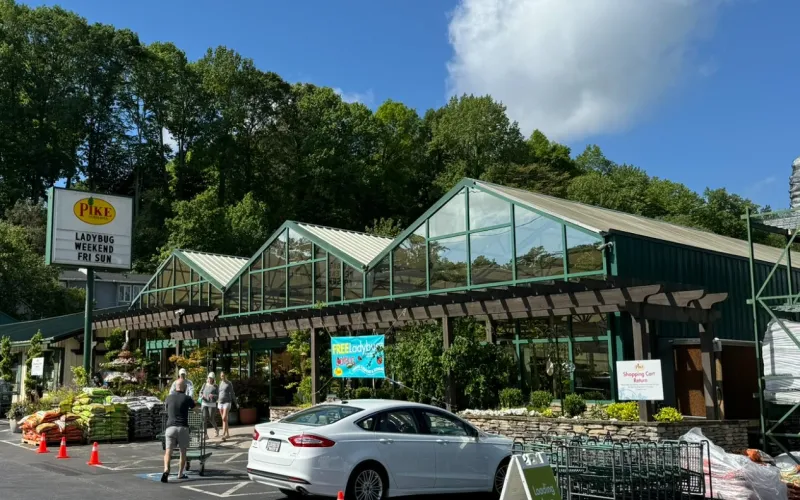 a building with a parking lot and trees in the background