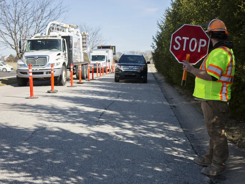 Man holding a stop sign to manage traffic safety