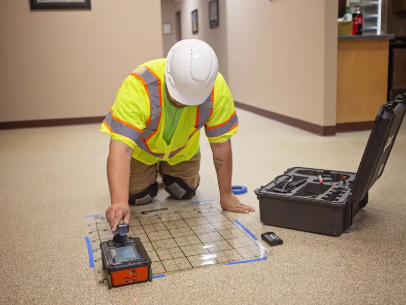 Man using concrete scanning equipment to find plumbing, fiber optic, electrical cable, and tension cables