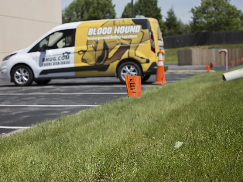 Blood Hound Underground Utility Locating high visibility lawn markers and van