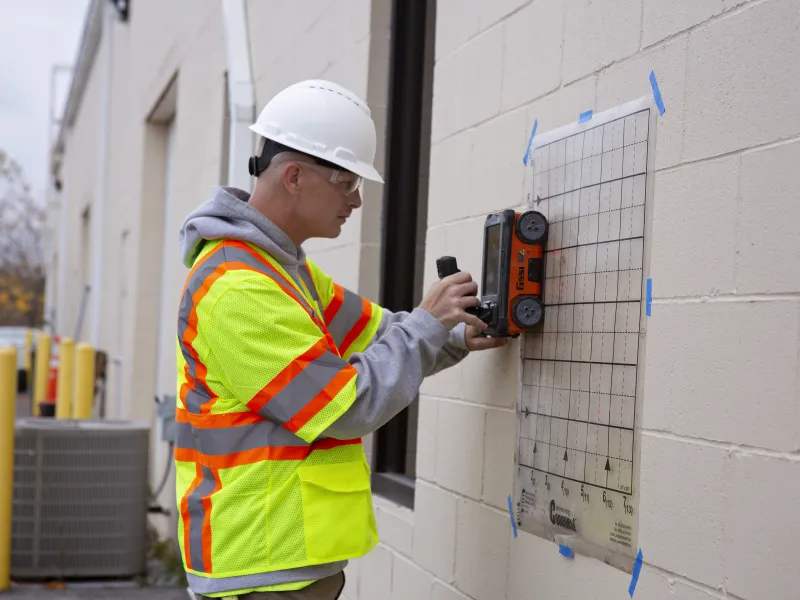 Man using concrete scanning equipment to find plumbing, fiber optic, electrical cable, and tension cables