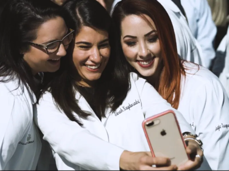 a group of women looking at a cell phone