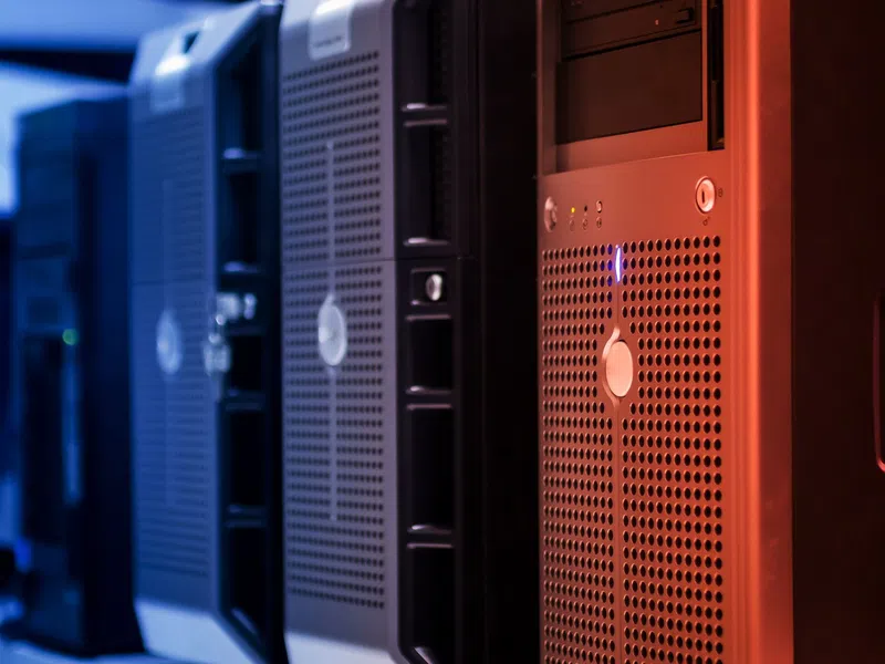 Close-up of multiple black computer servers with ventilation grilles in a data center rack.