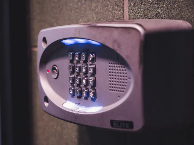 Security keypad with illuminated buttons mounted on a wall for controlled access entry.
