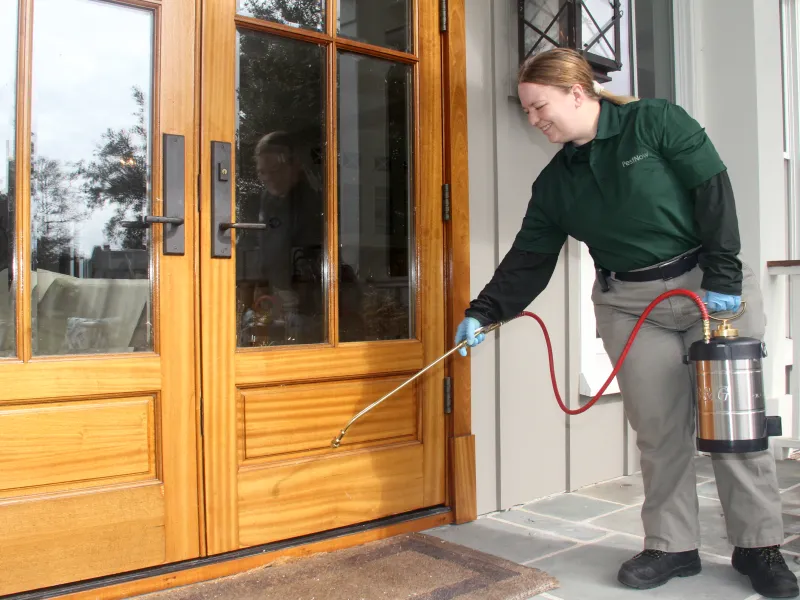 a person holding a hose to a door