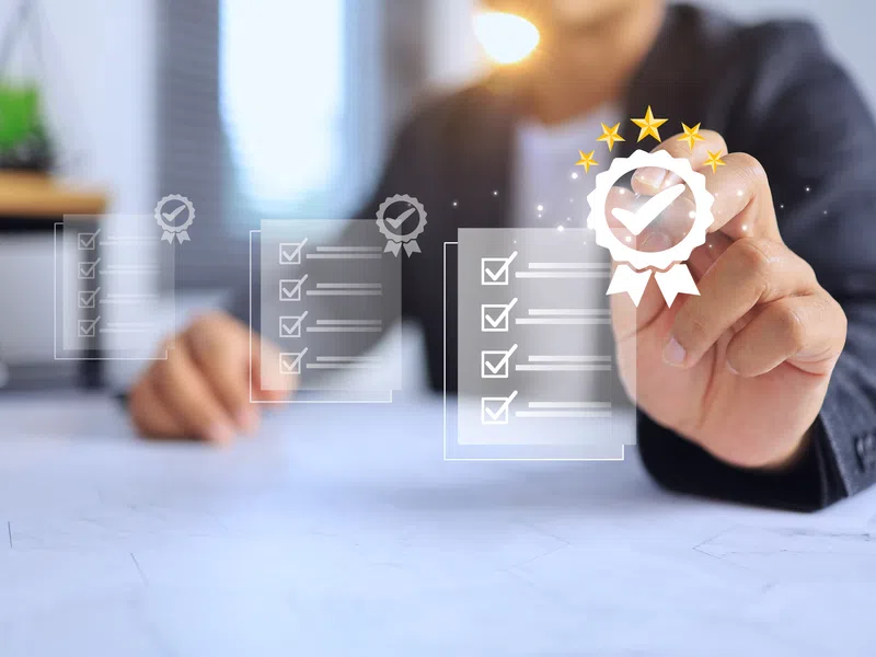 Person selecting checklist with checkmarks and quality seal icons symbolizing approval and success.