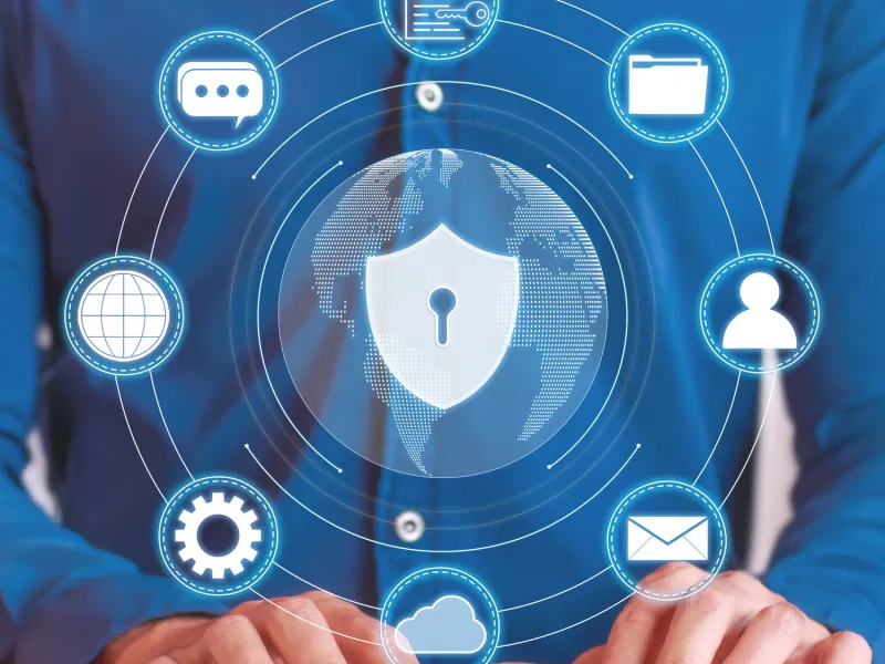 Person typing on a keyboard with digital security icons and a globe illustration around them.