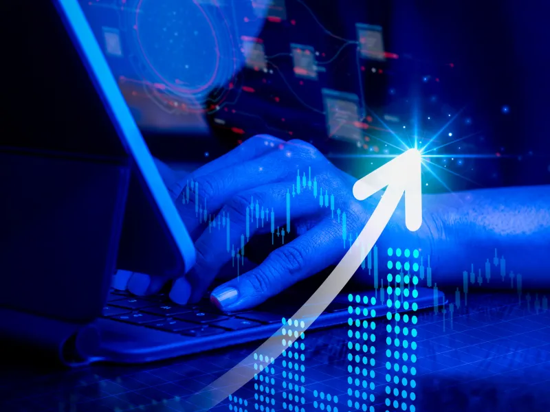 A person typing on a laptop with a digital growth graph and arrows illustrating progress.