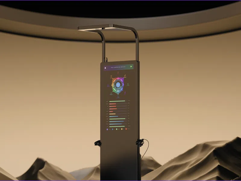 Tall digital kiosk with colorful data charts stands in desert landscape under a curved ceiling structure.
