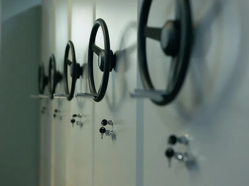 Close-up of multiple black handwheels on white storage cabinets with key locks in a row.