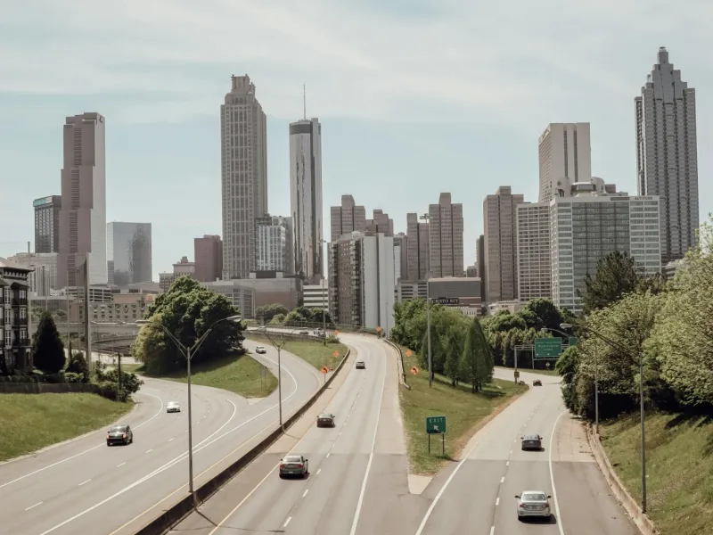 a city skyline with cars driving on a road