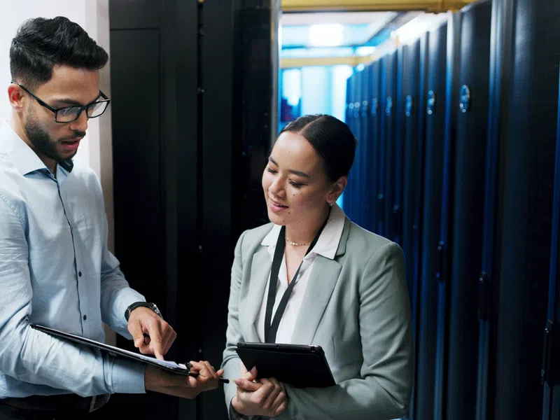 IT professionals discussing data server maintenance in a modern data center with server racks in the background