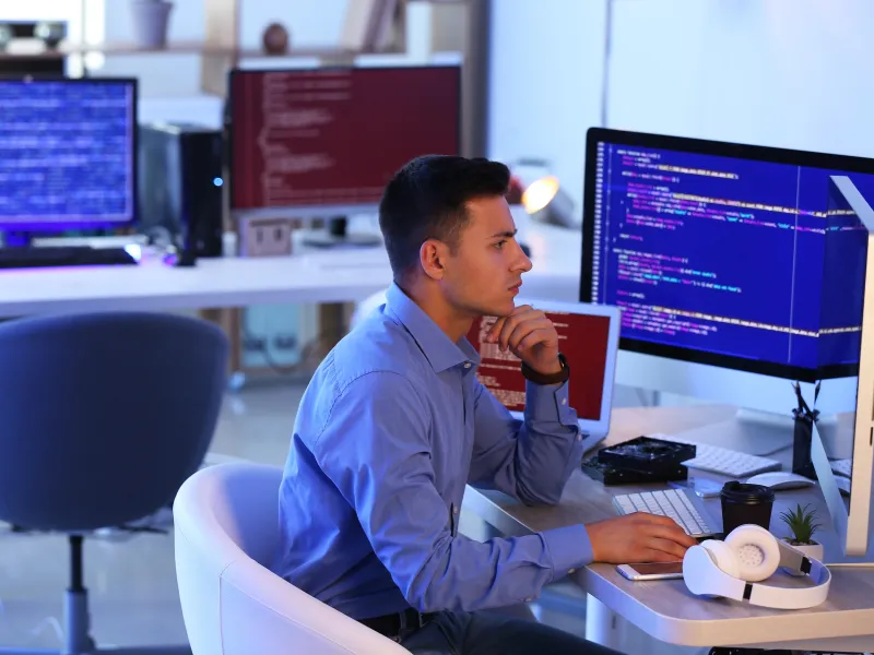 a man sitting at a desk with a microphone and a computer