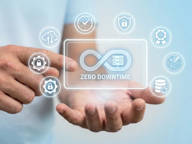 Hand holding digital interface showing infinity symbol labeled Zero Downtime with security and data icons.