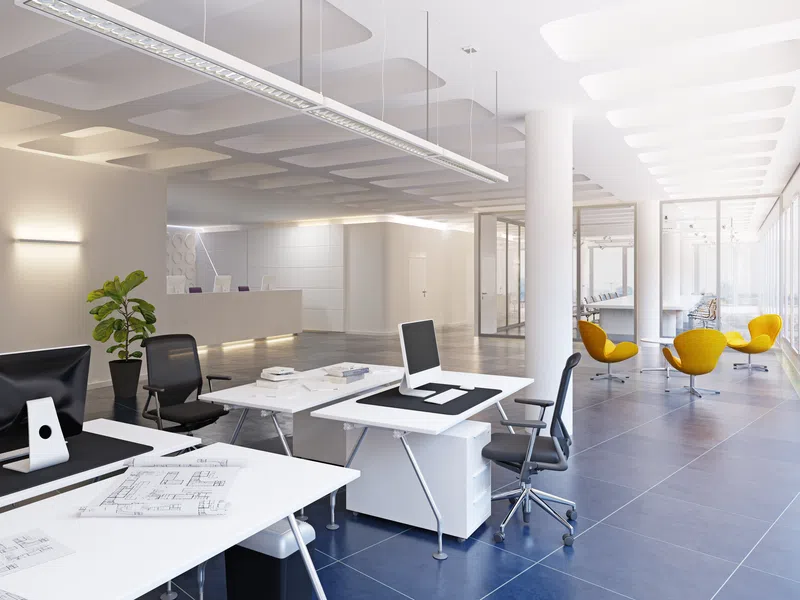 Modern bright office interior with white desks, black chairs, yellow lounge chairs, and large windows.