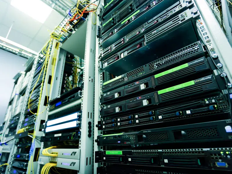Close-up of server racks with network cables in a data center environment focused on hardware and connectivity.