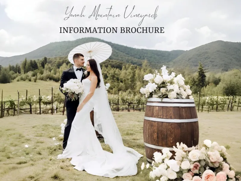 Bride and groom holding flowers and parasol in vineyard with mountain backdrop and floral barrel display