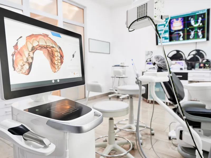 Digital 3D dental scan displayed on a monitor in a modern dental clinic treatment room.