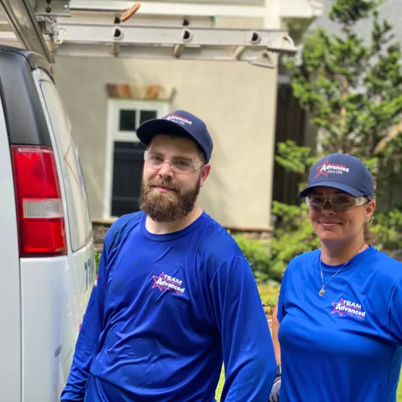 a man and a woman in blue shirts standing next to a car