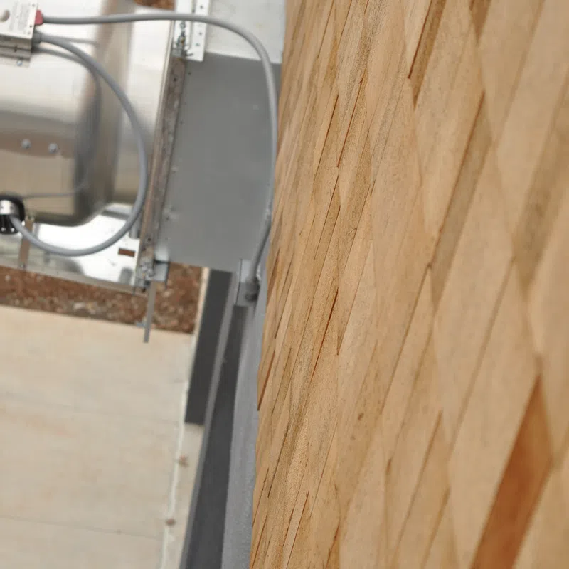 Close-up of a wooden shingle roof with part of a rooftop air conditioning unit in the background.