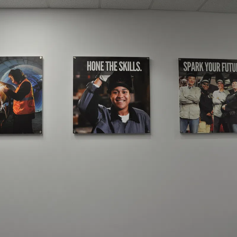 Three wall posters promoting welding skills with images of welders and motivational text.