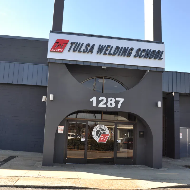 Front entrance of Tulsa Welding School building with clear signage and address 1287 on a sunny day.