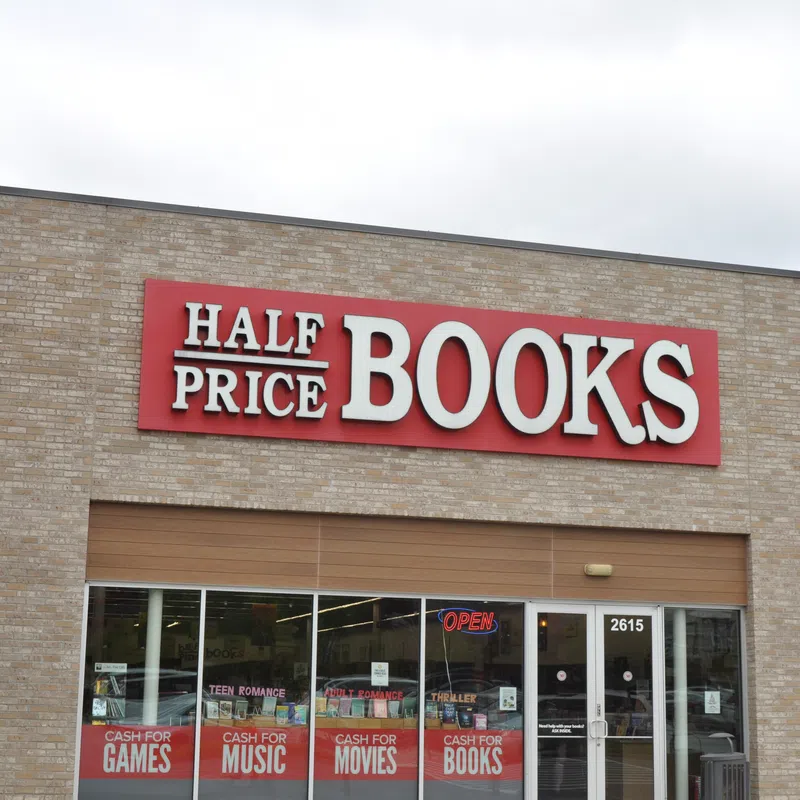 Exterior of Half Price Books store with signage advertising cash for games, music, movies, and books.