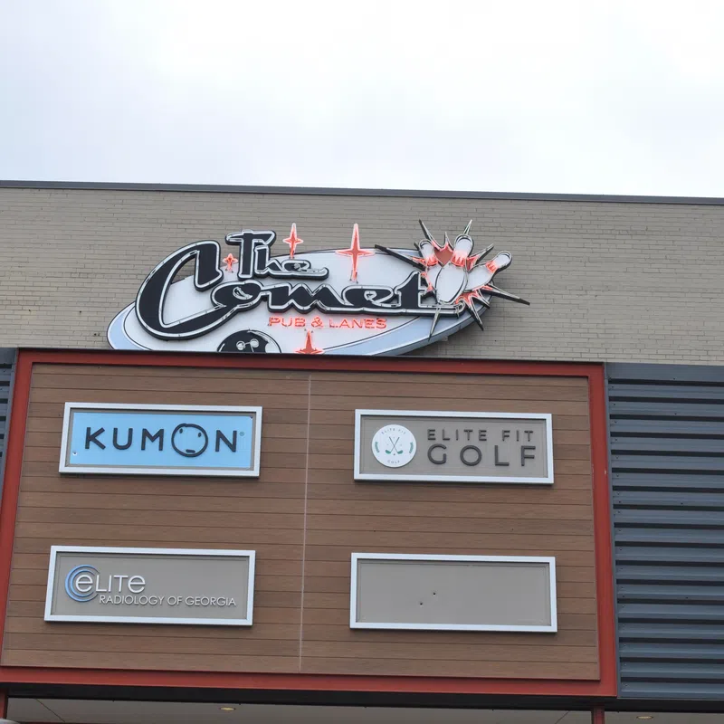 Storefront signs for Kumon, Elite Fit Golf, Elite Radiology of Georgia, and The Comet Pub & Lanes on a commercial building.