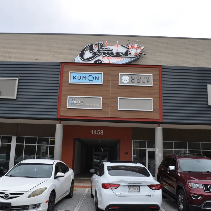 Front view of a commercial building with parked cars and signs for Kumon, Elite Golf, OB/GYN, and dental offices.