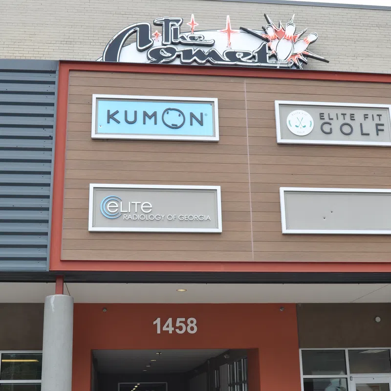 Storefront signs for Kumon, Elite Fit Golf, and Elite Radiology of Georgia on a building facade with address 1458