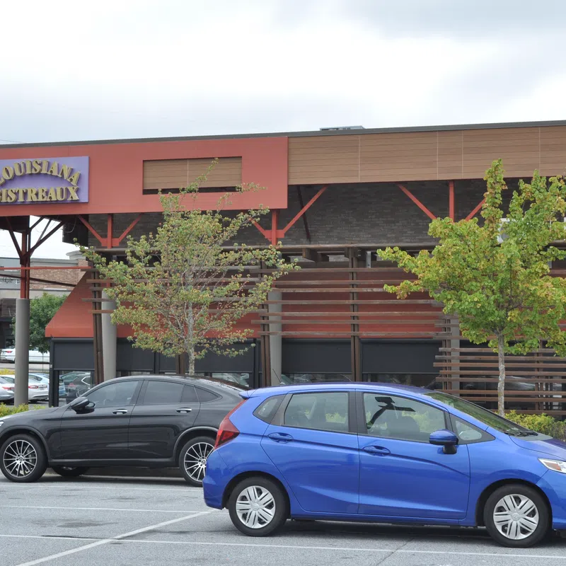 Louisiana Bistreaux restaurant exterior with parked cars in front on a cloudy day.