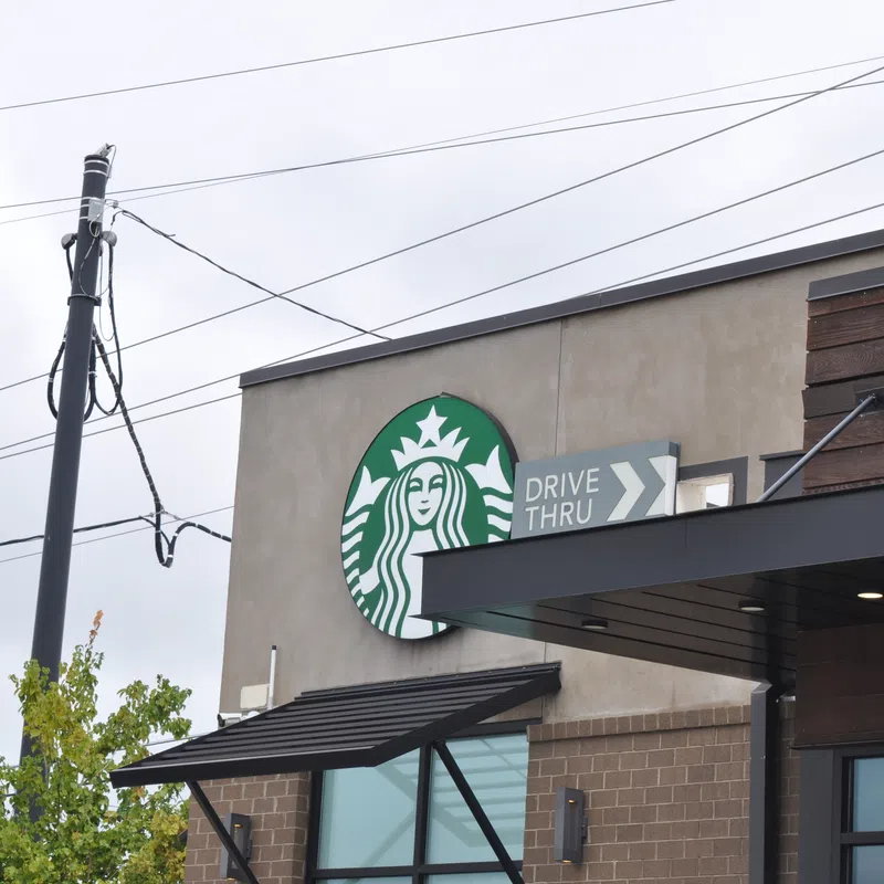 Starbucks coffee shop exterior with drive-thru sign on a cloudy day