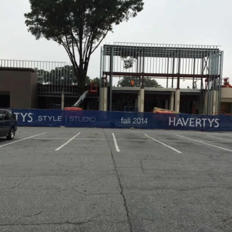 Construction site with Havertys Style Studio banner and a partially built steel structure behind a parking lot.