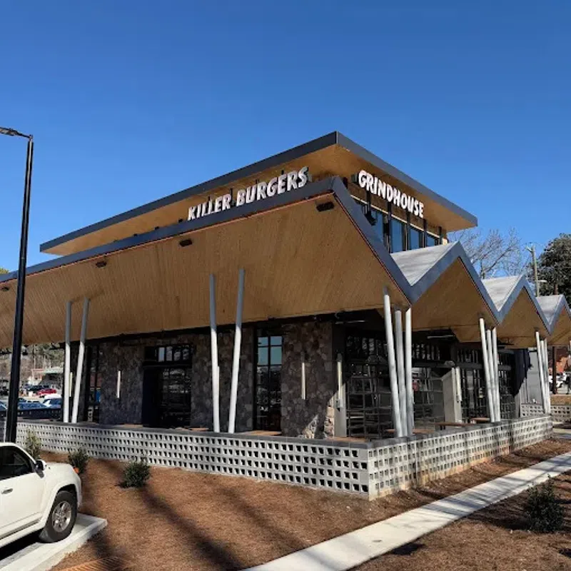 Modern restaurant building with unique angled roof and signage for Killer Burgers and Grindhouse on sunny day.