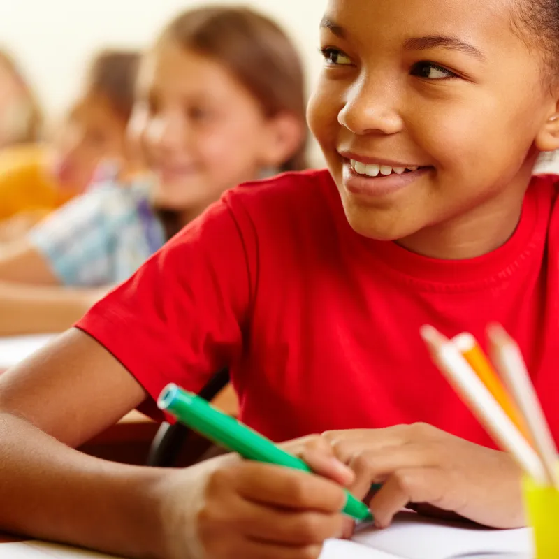 a young girl writing on a piece of paper