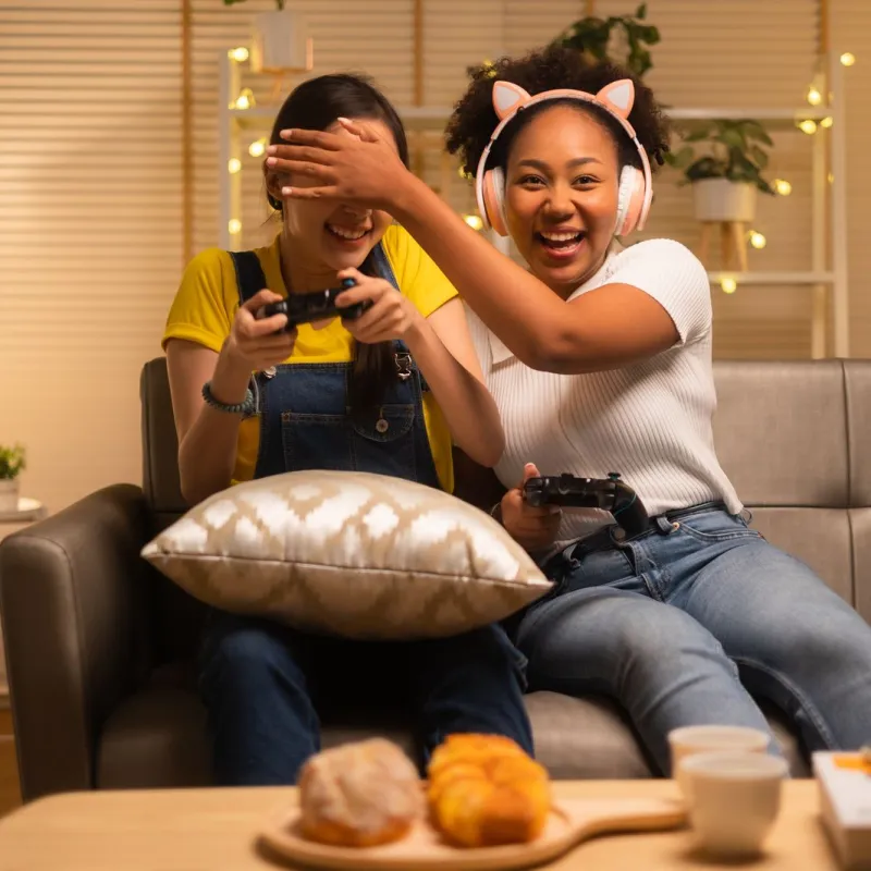 a woman and a boy sitting on a couch with a video game controller