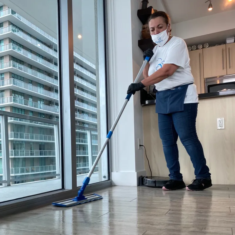 MaidPro Hudson house cleaner mopping a hardwood floor in a skyrise in Florida