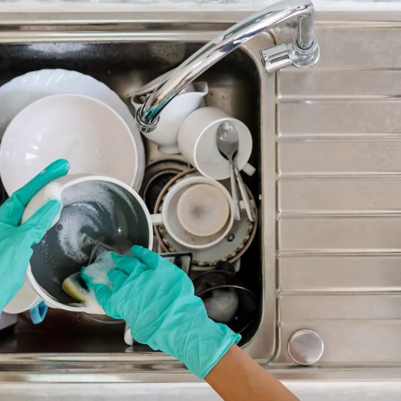 a person in a mask and gloves in a sink