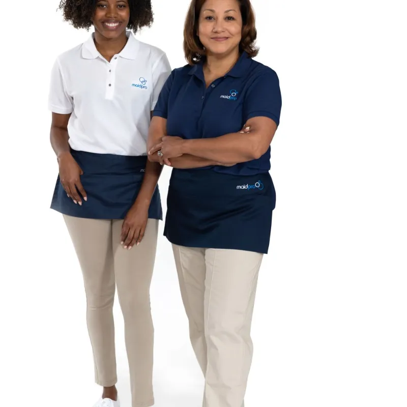 Two smiling women in MaidPro uniforms with navy aprons, standing confidently against white background.