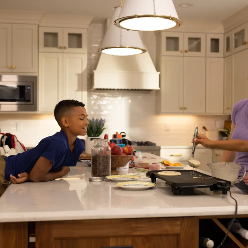 a person and a couple of kids in a kitchen