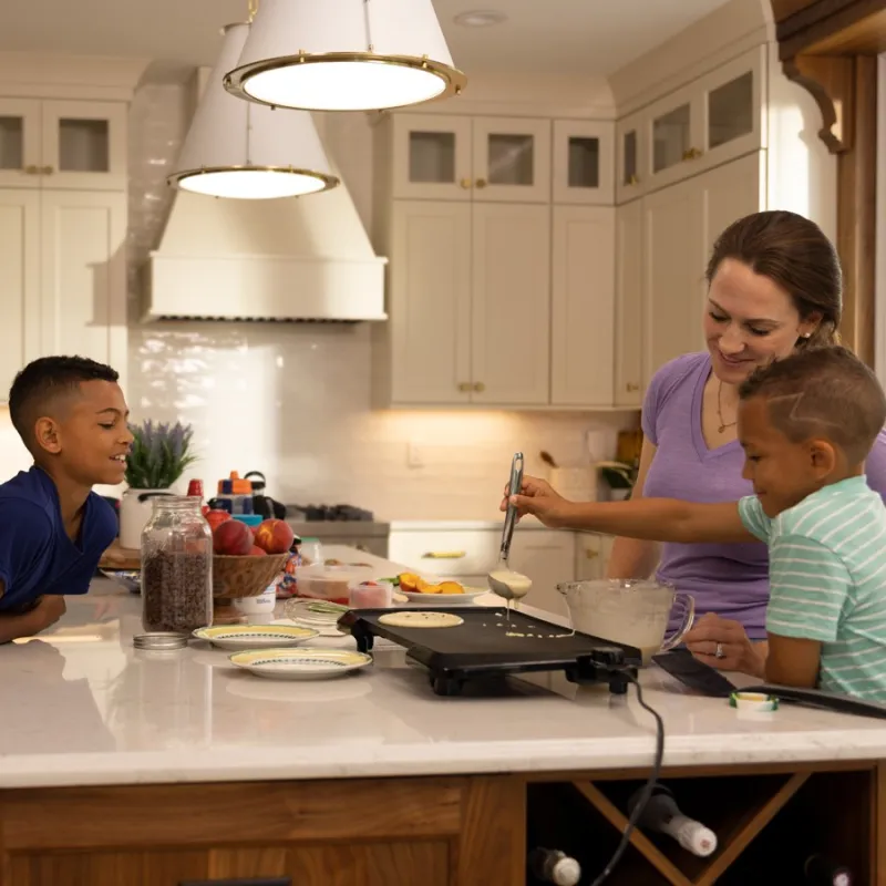 a person and a couple of kids in a kitchen