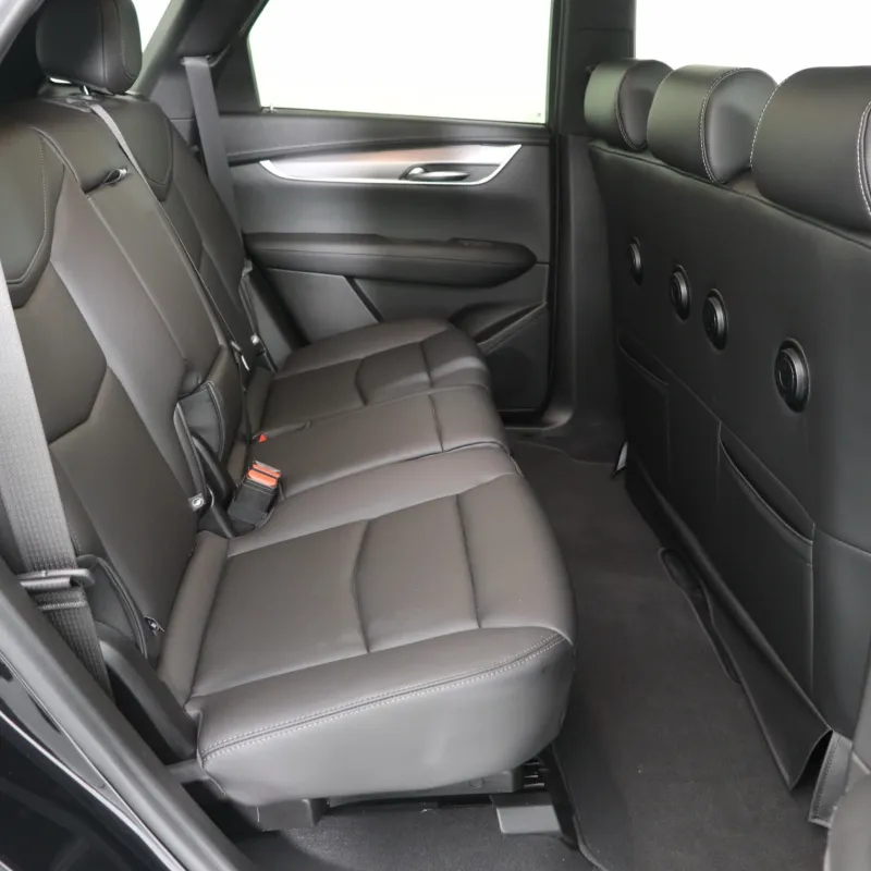 Interior view of a luxury SUV's rear seating area with black leather upholstery.