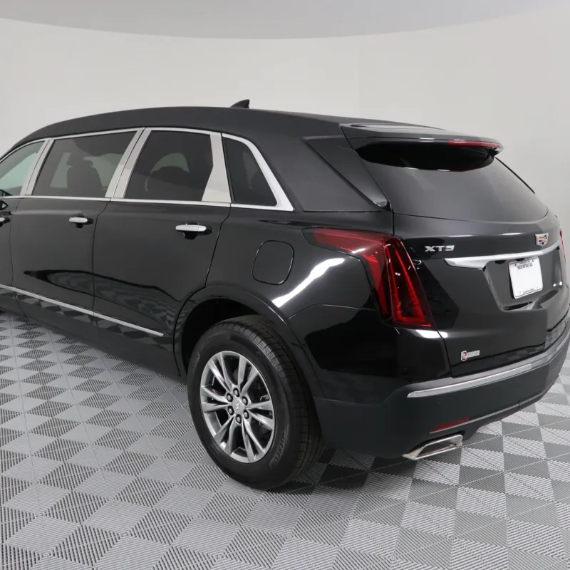Black Cadillac XT5 rear view showcasing luxury and sleek design in a studio setting.