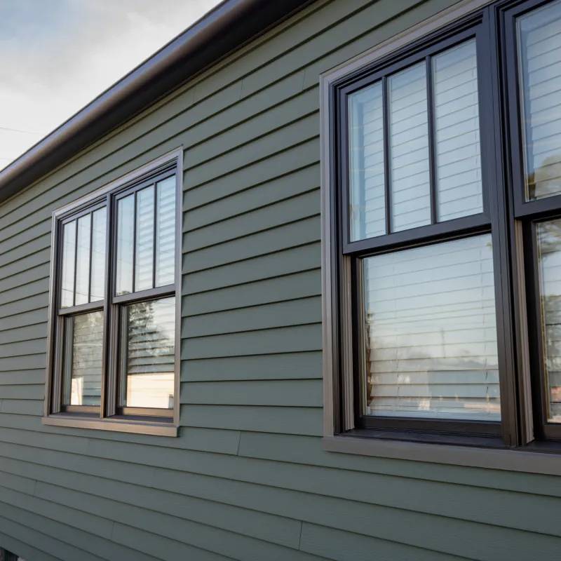 Green siding house with stone veneer and dark-trim windows upgraded by Nelson Exteriors in Marietta.