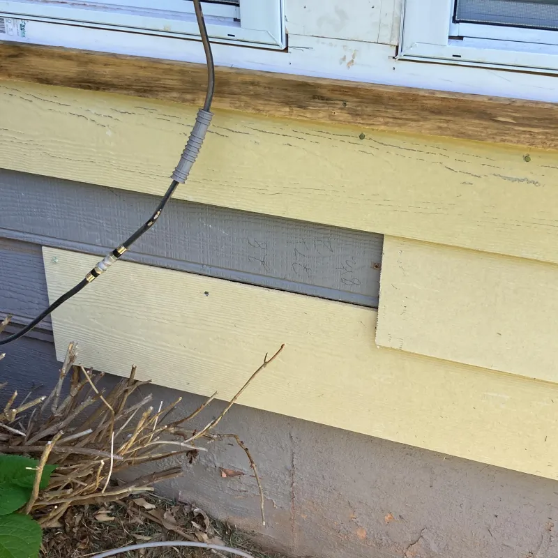 Yellow siding falling off a home and missing boards with wood rot Nelson Exteriors in Atlanta, GA
