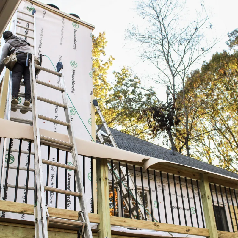 a person on a ladder painting a house